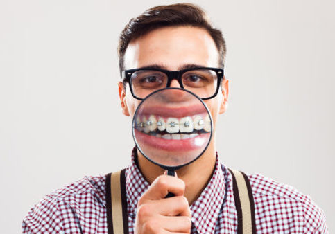 Nerdy,Man,Is,Holding,Loupe,And,Showing,His,Teeth,With